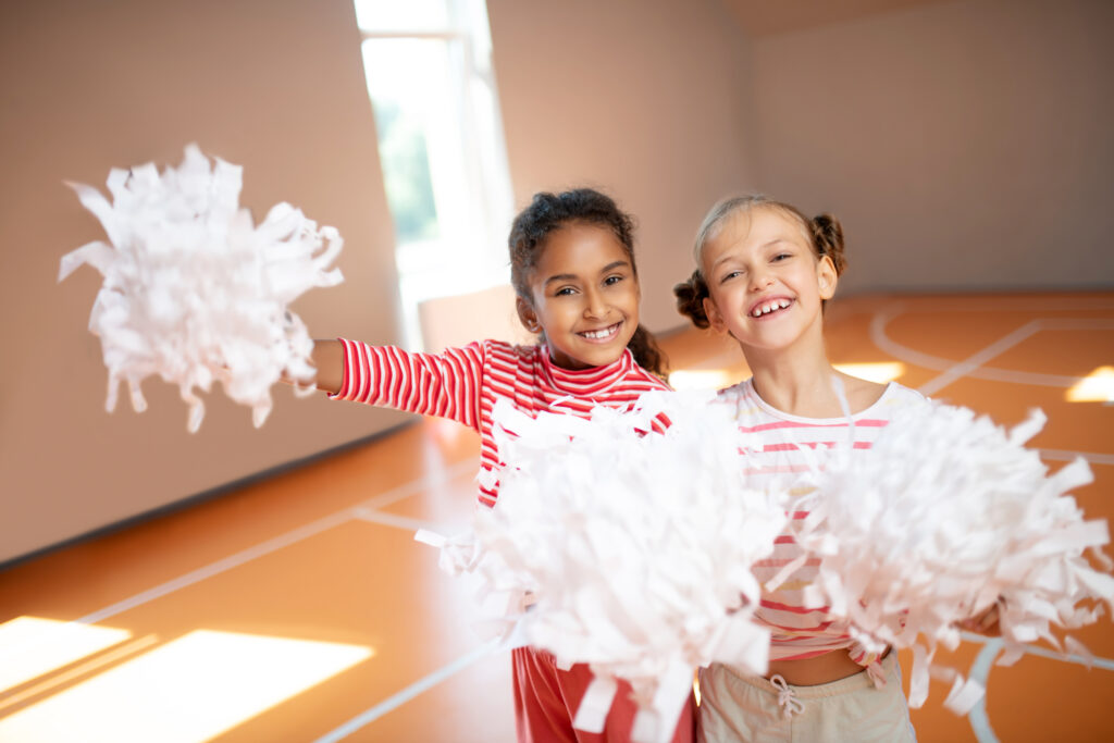 Best friends smiling while practicing cheerleading together
